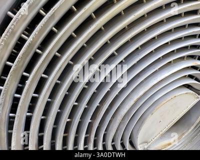 Nahaufnahme eines Spiralwärmetauschers aus Edelstahl mit detaillierter Spulenstruktur in einer Fertigungsanlage bei Tageslicht. Stockfoto