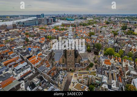 Atemberaubende Aussicht auf Westerkerk, die protestantische Kirche in Amsterdam und die ikonische Architektur, Kanäle und pulsierende Stadtlandschaft. Stockfoto