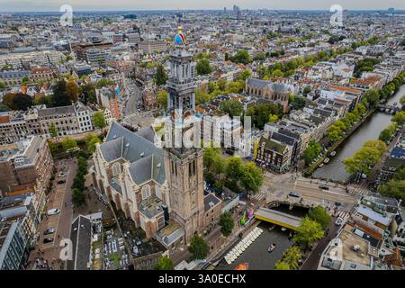 Atemberaubende Aussicht auf Westerkerk, die protestantische Kirche in Amsterdam und die ikonische Architektur, Kanäle und pulsierende Stadtlandschaft. Stockfoto