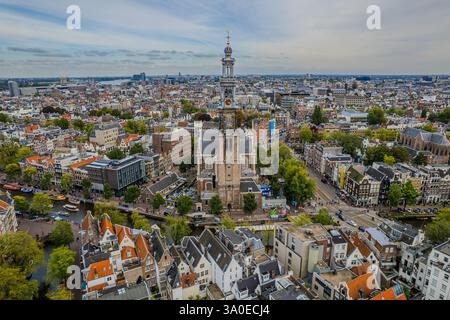 Atemberaubende Aussicht auf Westerkerk, die protestantische Kirche in Amsterdam und die ikonische Architektur, Kanäle und pulsierende Stadtlandschaft. Stockfoto