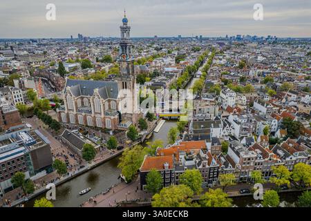 Atemberaubende Aussicht auf Westerkerk, die protestantische Kirche in Amsterdam und die ikonische Architektur, Kanäle und pulsierende Stadtlandschaft. Stockfoto