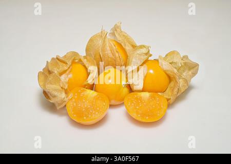 Nahaufnahme reifer kapstachelbeerfrüchte, mit gelben Beeren, die längs geschnitten sind, auf weißem Hintergrund Stockfoto