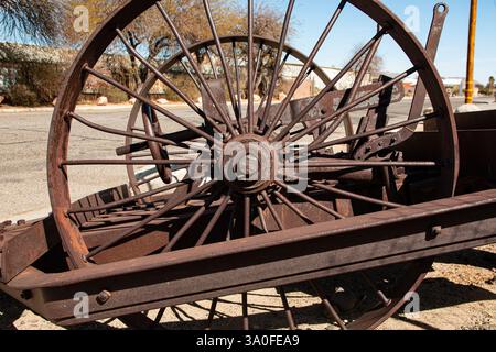 Abstraktes Muster aus den rostigen Stahlspeichen auf Rädern einer alten Baumaschine. Stockfoto