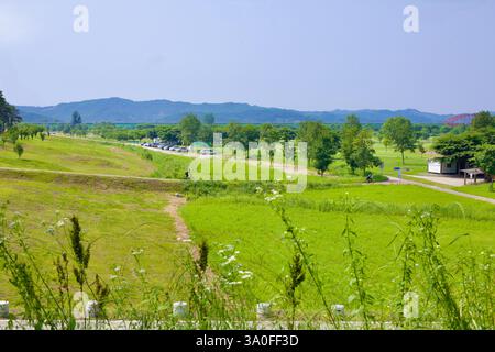 Buyeo County, Südkorea - 27. Mai 2021: Ein malerischer Blick auf den Narae Park mit üppigen grünen Feldern, einem gewundenen Radweg und Radfahrern entlang des Parks Stockfoto