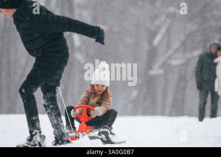 Spaß beim Schlittenfahren. Glückliche Familie ist draußen und genießt im Winter gemeinsam Schnee. Stockfoto