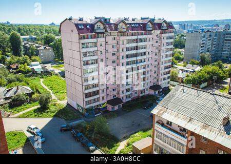 Ein Blick auf Wohngebäude in einem städtischen Viertel mit typisch sowjetischer Architektur mit Ziegelstein- und Betonbauten an einem sonnigen Tag Stockfoto