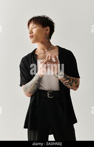 Der modische junge Mann zeigt einen einzigartigen Stil in einem minimalistischen Studio mit kreativer Beleuchtung. Stockfoto