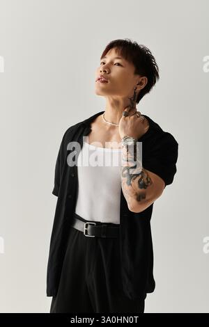 Der junge gutaussehende Mann zeigt seinen einzigartigen Stil und sein Selbstvertrauen in einer modernen Studioumgebung. Stockfoto