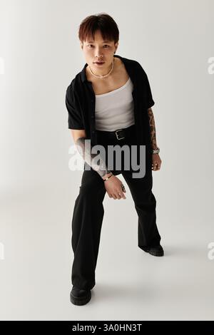 Der junge Mann zeigt sein Gespür für Mode mit einer auffälligen Pose, die Stil und Individualität ausstrahlt. Stockfoto