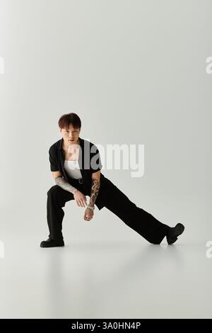 Ein junger, gutaussehender asiatischer Mann zeigt seinen trendigen Stil, während er drinnen dramatisch posiert. Stockfoto