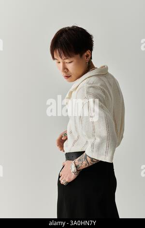 Ein junger asiatischer Mann mit stilvoller Frisur zeigt sein Gespür für Mode mit Eleganz und Gemütlichkeit. Stockfoto