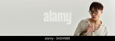 Ein junger und gutaussehender asiatischer Mann zeigt seinen Stil, während er drinnen selbstbewusst posiert. Stockfoto