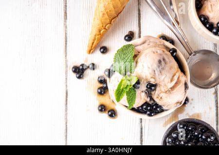 Bubble Milk Tee Eiscreme, süßer taiwanesischer Milchtee nach asiatischer Art mit Kuromitsu, schwarzen boba- oder Tapioka-Perlen und Sirup, in portionierten Schüsseln mit Eis c Stockfoto