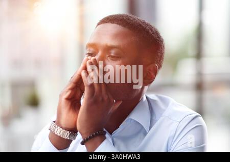Porträt eines nachdenklichen, authentischen afroamerikanischen Mannes, der auf den Computer schaut Stockfoto
