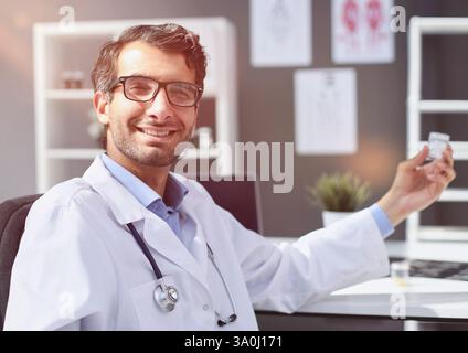 Der Arzt streckt seine Hand mit einem Glas Pillen aus Stockfoto