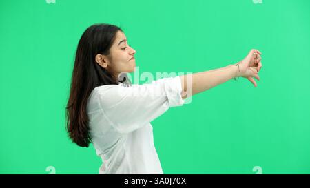 Eine Frau aus der Nähe auf grünem Hintergrund zeigt ihre Daumen nach unten Stockfoto