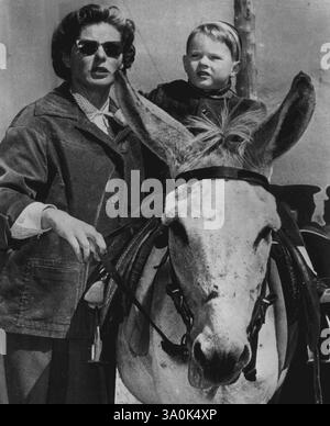 Eselfahrt für Robertino – Schauspielerin Ingrid Bergman gibt ihrem Sohn, dem dreijährigen Robertino Rossellini, einen Eselritt während eines Picknicks auf der Insel Capri am 19. März mit ihrem Mann, dem italienischen Filmregisseur Roberto Rossellini. Die Schauspielerin und ihr Mann nahmen sich den Tag von ihrer Filmarbeit in Neapel frei. März 1953. (Foto von AP Wirephoto) Stockfoto