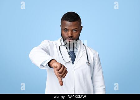 Wütend junge schwarze Arzt mit Daumen nach unten Stockfoto