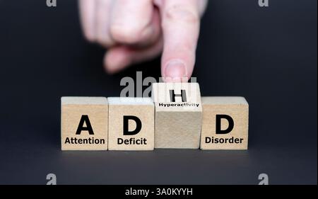 Die Hand dreht den Würfel und ändert das Akronym ADD (Aufmerksamkeitsdefizit-Störung) zu ADHS (Aufmerksamkeitsdefizit-Hyperaktivitätsstörung). Stockfoto