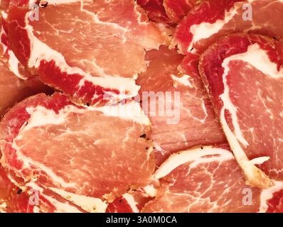 Herzhafte Scheiben von geräuchertem Fleisch, wunderschön angeordnet für ein verführerisches kulinarisches Erlebnis Stockfoto