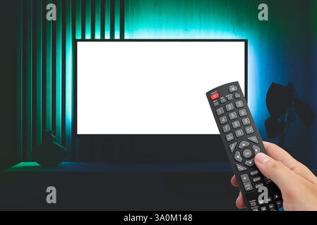 Moderne Wohnzimmereinrichtung mit leerem Smart-TV. TV-Konzept, Fernbedienung in der Hand Stockfoto