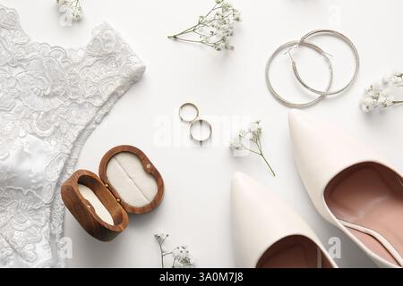 Eheringe, Ohrringe, Holzbox, Kleid und Absätze auf weißem Hintergrund. Draufsicht Stockfoto
