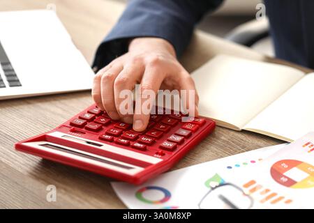 Männliche Hand, die Berechnungen im Büro macht. Nahaufnahme Stockfoto