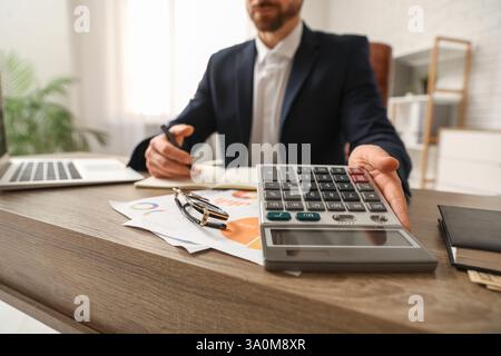 Ein Buchhalter, der im Amt Berechnungen macht. Nahaufnahme Stockfoto
