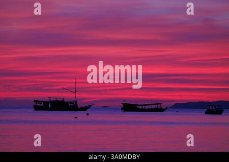 Blick auf den Sonnenaufgang auf das Boot vor der Insel Seraja Kecil, auch bekannt als Seraya, vor der Küste von Labuan Bajo, Indonesien. Stockfoto