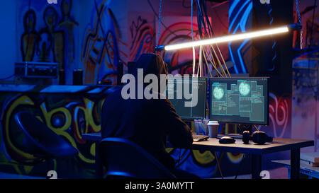 Enthüllende Aufnahme von Spionen mit VPN und Darknet als Anonymität-Tools, um Online-Identität zu verschleiern und Regierungsgeheimnisse zu stehlen. Mann im unterirdischen Bunker maskiert seinen Standort, begeht Spionage, Kamera B Stockfoto