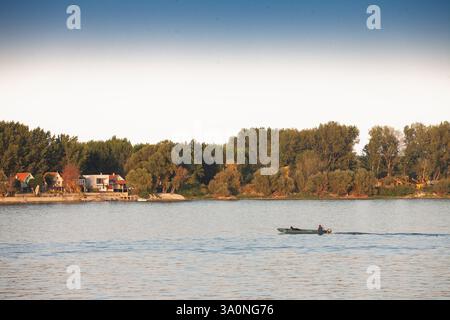 BELGRAD, SERBIEN - 12. OKTOBER 2024: fischer mit einem kleinen Motorboot auf den ruhigen Gewässern der Donau in Belgrad, Serbien, die lokale Fischerkultur zeigen Stockfoto