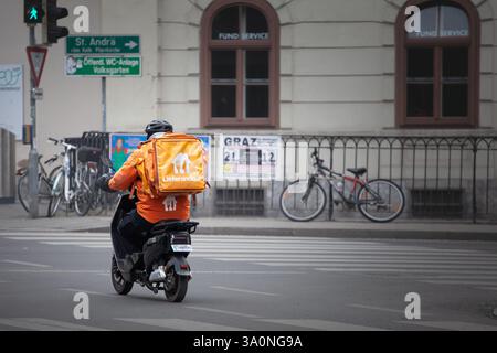 GRAZ, ÖSTERREICH - 17. DEZEMBER 2024: Lieferando-Logo auf einem Liefermann in Graz. Teil von Just Eat ist ein österreichischer Essenslieferservice. Stockfoto