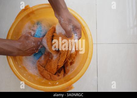 Hände waschen Tuch in orangefarbener Wanne gefüllt mit Seife und Wasser Stockfoto