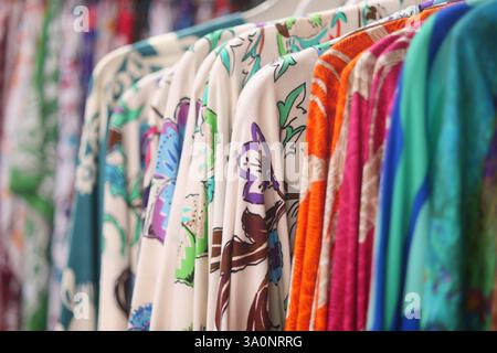 Farbenfrohe Kleiderständer mit lebendigen Stoffen in einer Boutique Stockfoto