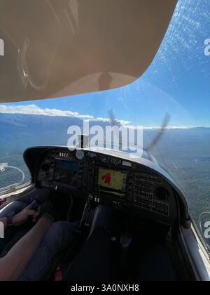 Blick aus dem Cockpit eines Hubschraubers, der über einen dichten Wald fliegt Stockfoto