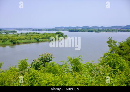 Iksan City, Südkorea - 27. Mai 2021: Ein malerischer Blick auf den Geum River von einem Hügel mit kleinen Inseln bedeckt mit dichtem Grün und ruhigen Gewässern Stockfoto