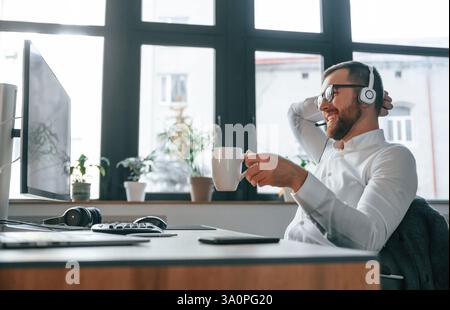 Büroangestellte in formeller Kleidung sitzt am Computer und arbeitet. Stockfoto