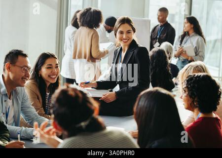Eine vielfältige Gruppe von Geschäftsleuten arbeitet in einem modernen Büroumfeld an einer Strategie zusammen, wobei Teamarbeit und Innovation im Vordergrund stehen. Stockfoto