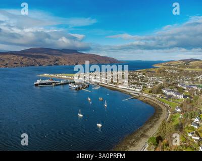 Ullapool Hafen und Dorf in Schottland und Loch Broom aus der Luft gesehen. Eine Caledonian MacBrayne Fähre kann man sehen, wie sie den Hafen verlässt Stockfoto