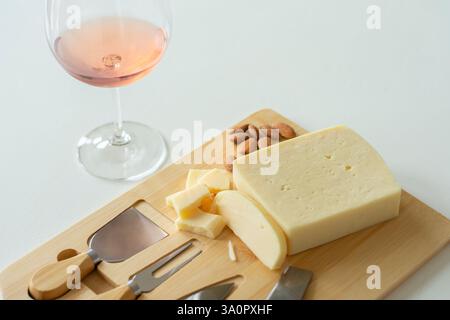 Käsebrett mit einem Glas Rosenwein und Mandeln Stockfoto