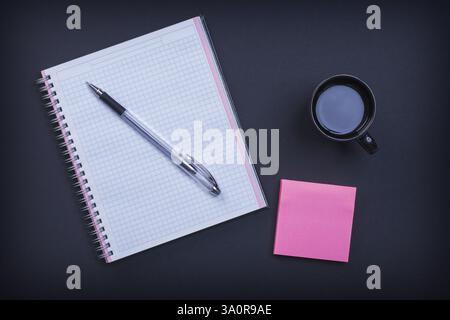 Haftnotiz und Tasse Kaffee auf schwarzem Hintergrund Stockfoto