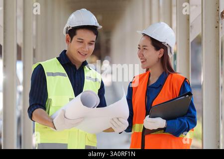 Nachhaltige Zusammenarbeit im Bauwesen. Zwei Ingenieure diskutieren Projektpläne auf einer Baustelle. Stockfoto