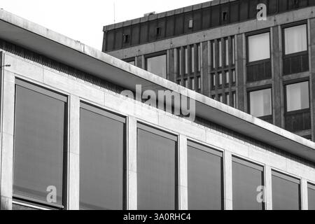 Moderne Betonfassade mit Fenstern und überhängendem Dach in Schwarz-weiß Stockfoto