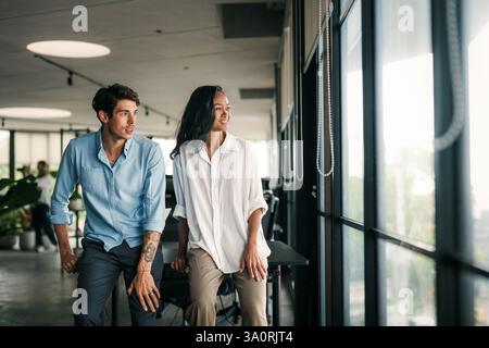 Multirassische Kollegen diskutieren über Startup-Projekte und lächeln während des Arbeitstages im Büro Stockfoto