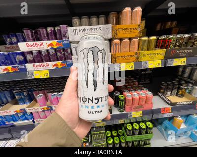 Deutschland Berlin 19. Februar 2025 Eine Person hält eine Monster Energy Drink Dose in der Hand. Der Laden ist voller Monster Energy Drinks. Es gibt viele verschiedene Stockfoto