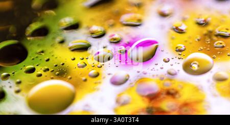 Abstrakte Makroaufnahme von Wassertropfen, die bunte Blumen reflektieren Stockfoto