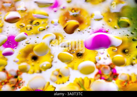 Abstrakte Nahaufnahme von Wassertropfen, die bunte Blumen reflektieren Stockfoto