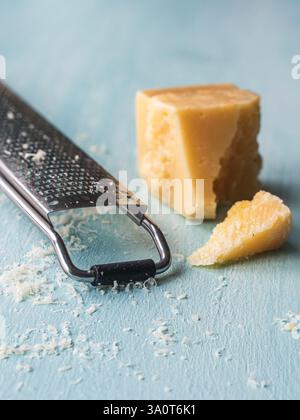 Parmesankäse wird auf blauem Hintergrund fein gerieben. Hochwertige Fotos Stockfoto