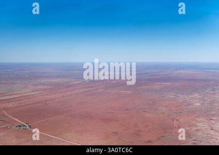 Luftlandschaft mit Bauernhof und C25-Feldweg in der roten Kalahari-Wüste, aufgenommen von einem Segelflugzeug in hellem Spätfrühlingslicht in der Nähe von Uhlenhorst, Namibia, A Stockfoto