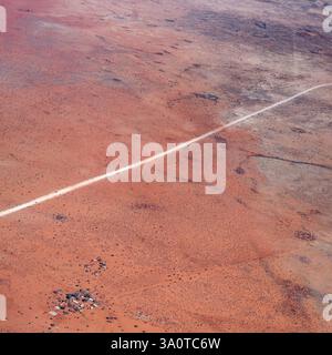 Luftlandschaft mit C15-Feldweg und Farm in der Kalahari-Wüste, aufgenommen von einem Segelflugzeug im hellen Licht des späten Frühlings in der Nähe von Bitterwasser, Namibia, AFR Stockfoto